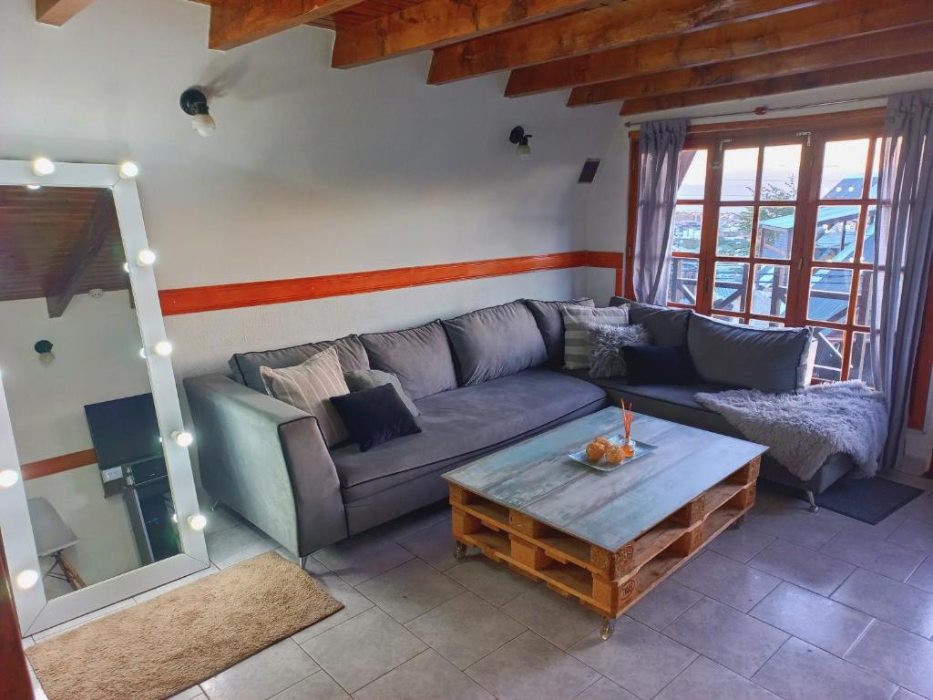 sala de estar con sofá y mesa de centro en Ushuaia magnífica, cabaña 3 dormitorios en Ushuaia