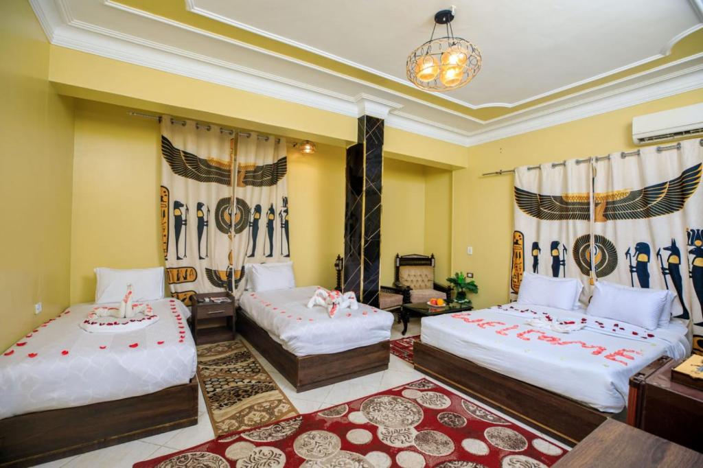 1 dormitorio con 2 camas y lámpara de araña en Bella Casa Pyramids Inn en El Cairo