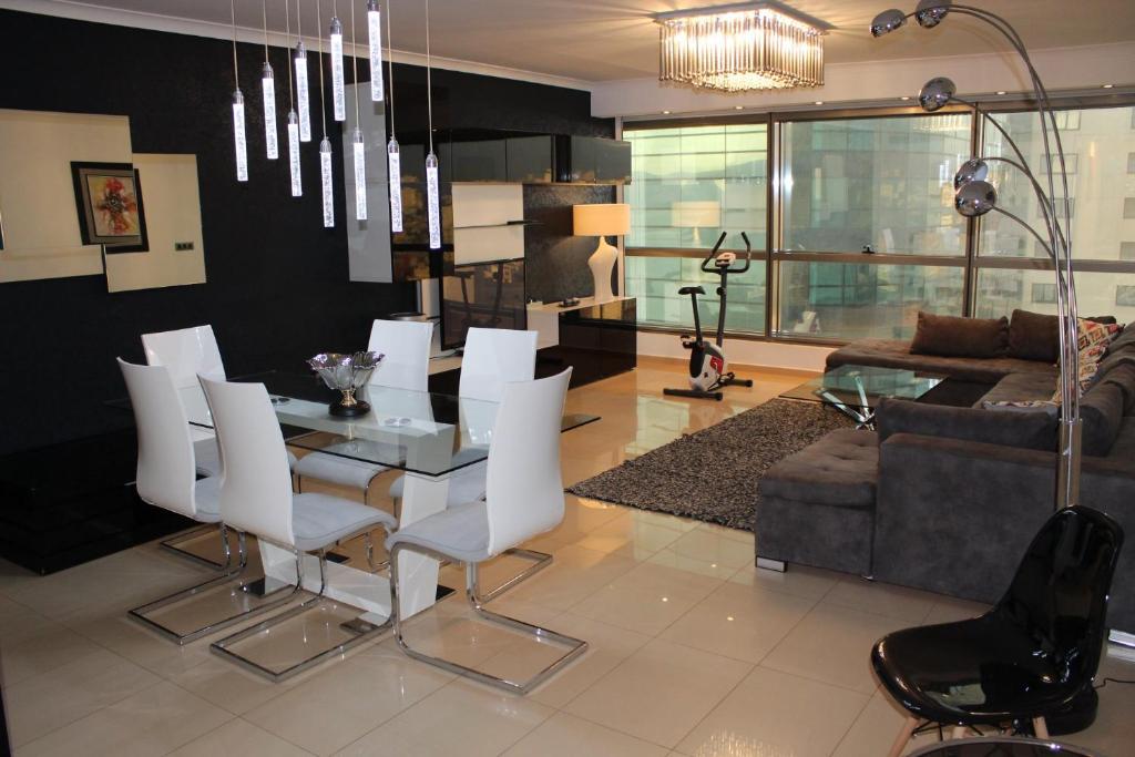 sala de estar con mesa de comedor y sillas blancas en Appart Luxe 5* de 180m² + Vue imprenable sur Oran, en Orán
