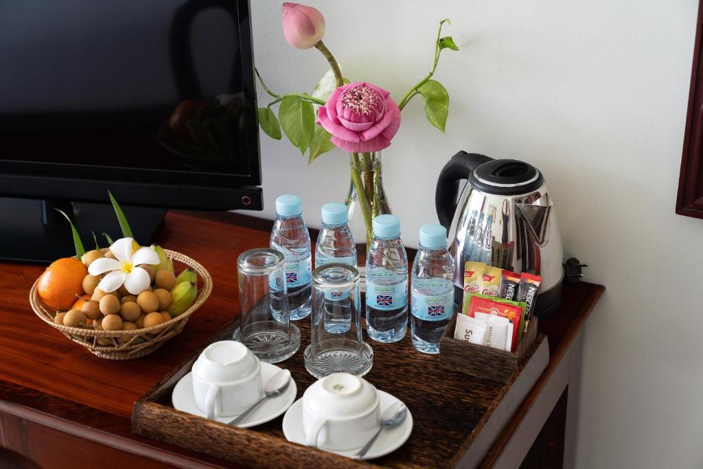 a table with bottles of water and a vase with flowers at Sala Siem Reap Hotel in Siem Reap