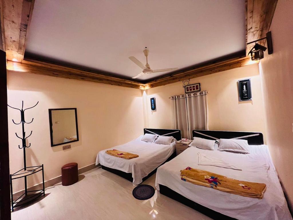 a bedroom with two beds and a mirror at Eco Divine Beach Resort- Saint Martin in Jaliapāra
