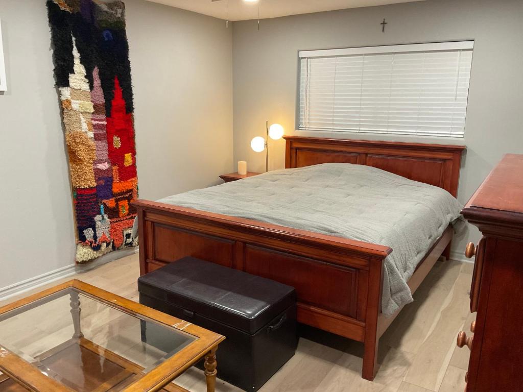 a bedroom with a bed and a window and a table at A Luxury Master Bedroom in a Condo in Los Angeles