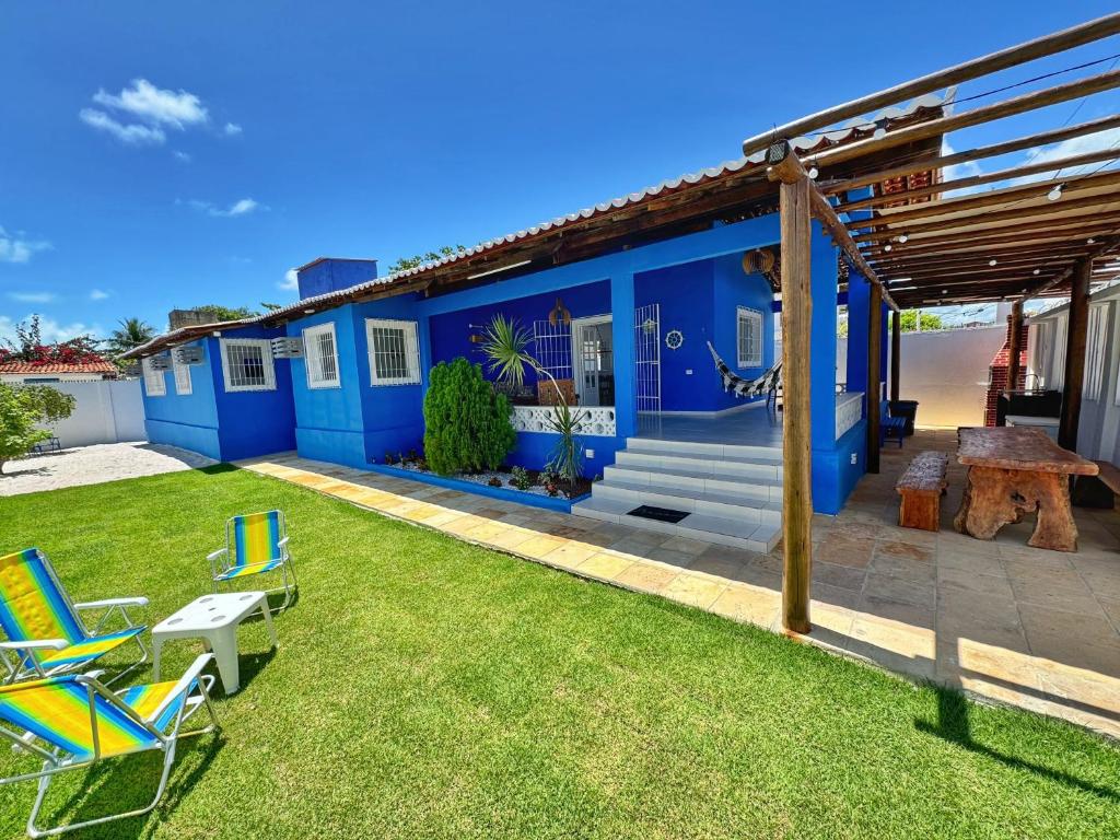 een blauw huis met stoelen en een tafel in de tuin bij Casa Coroa Grande! A Sua Casa de Praia em São José in São José da Coroa Grande