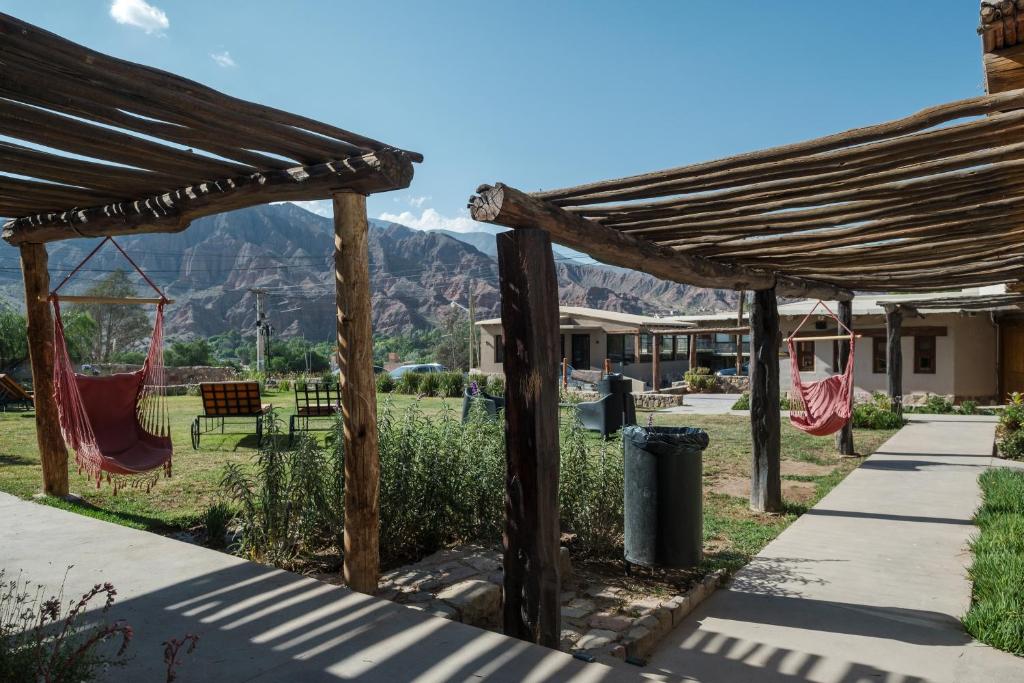 a wooden pergola with a hammock in a yard at Aguacanto Cabañas in Tilcara