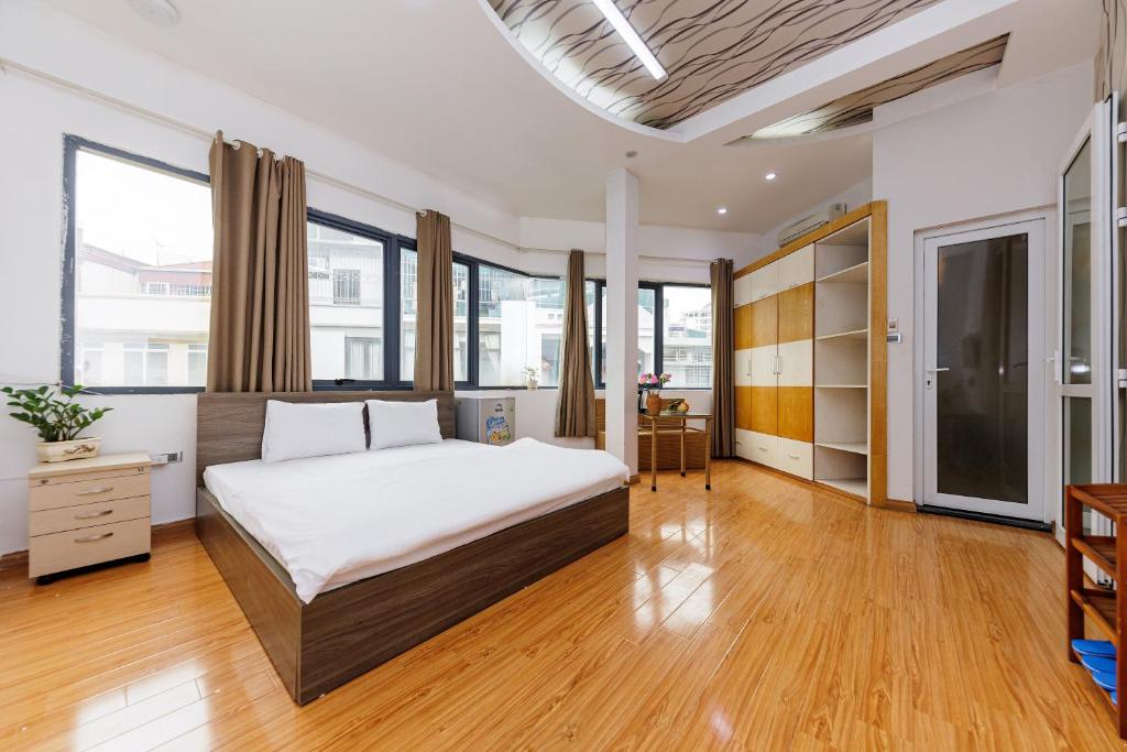 sypialnia z dużym łóżkiem i drewnianą podłogą w obiekcie Lamaison Hà Nội w mieście Hanoi