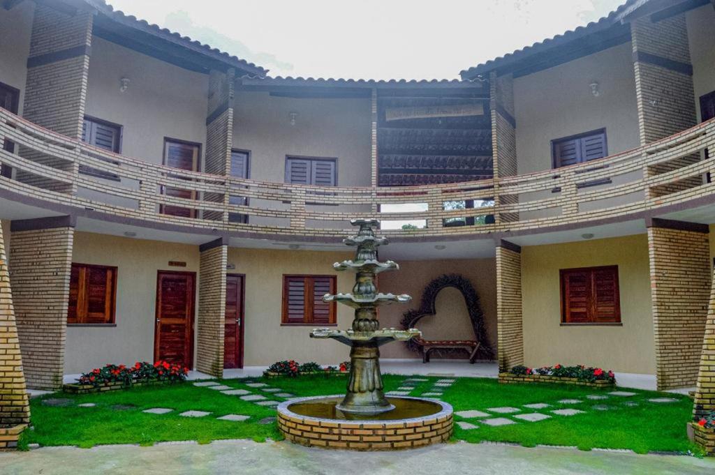 einen Innenhof mit einem Brunnen in der Mitte eines Gebäudes in der Unterkunft Ap Classic - Pousada Flor da Serra - Mulungu in Mulungu