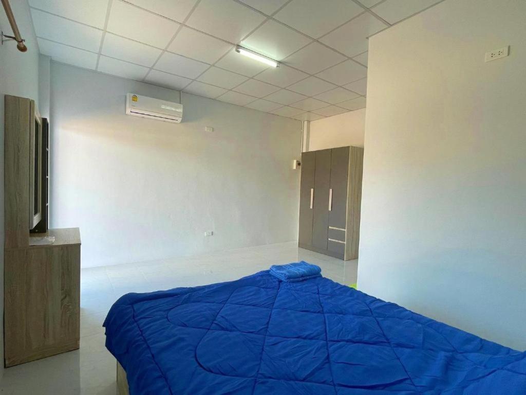 een slaapkamer met een blauw bed in een kamer bij Aviator Club in Ban Khong Krathin