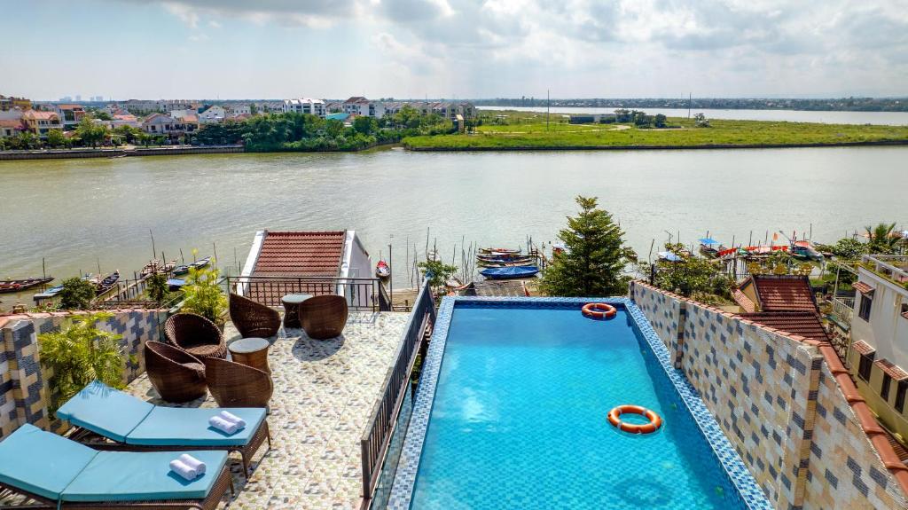 uma piscina ao lado de um rio em Rockmouse Centre River Villa Hoi An em Hoi An