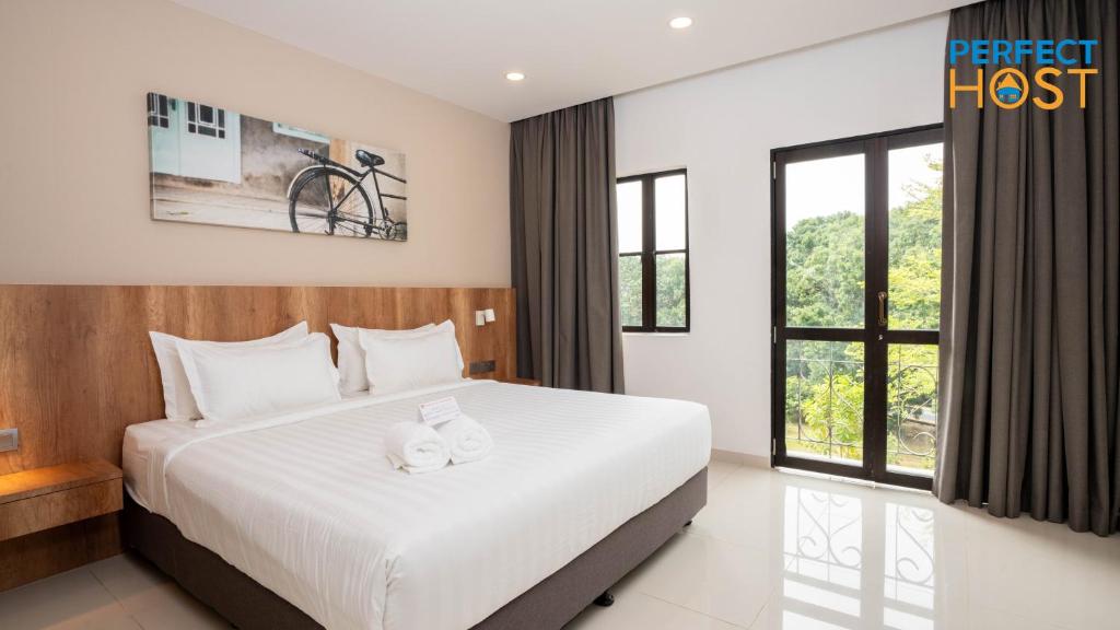 a bedroom with a bed and a large window at Damai Laut Escape by Perfect Host in Lumut
