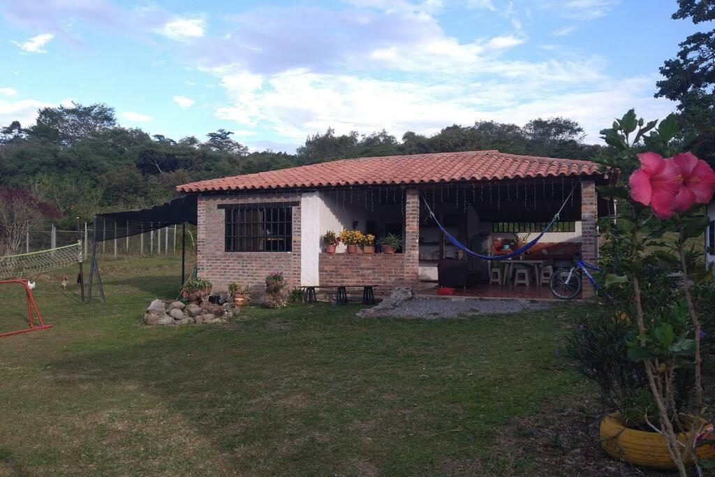 una pequeña casa de ladrillo con techo rojo en Cabaña el Gaque en Curití