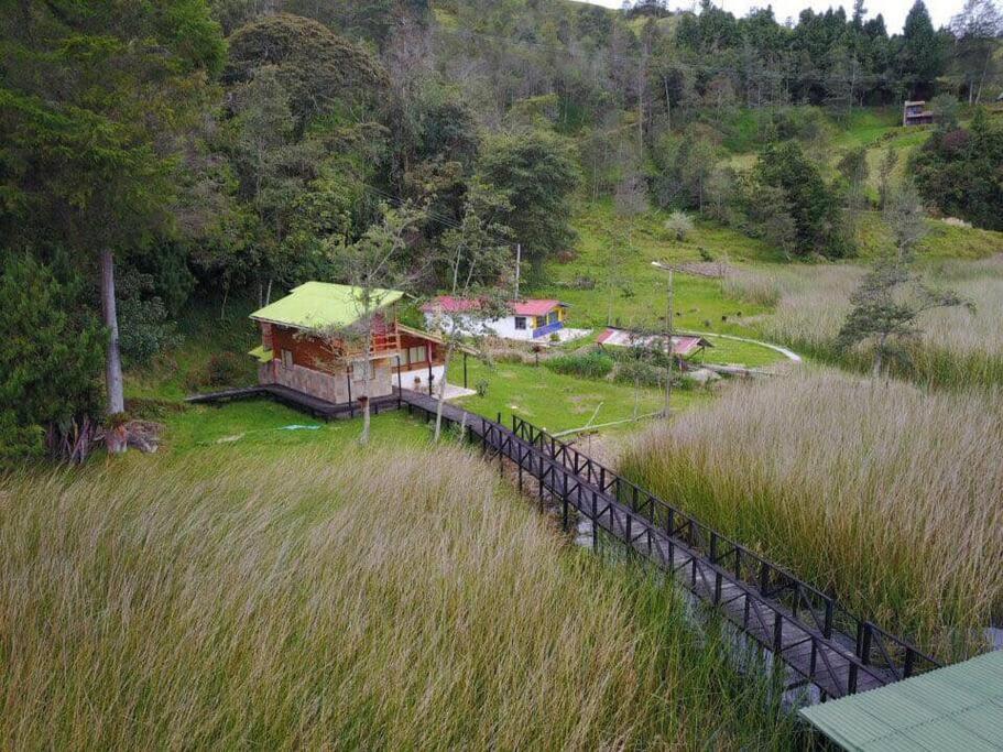 ein Haus inmitten eines Grasfeldes in der Unterkunft Killary, Laguna de La Cocha in Pasto