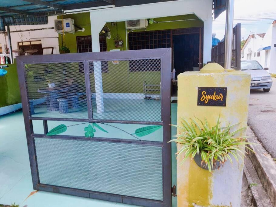 une cage pour oiseaux assise sur le côté d'une rue dans l'établissement Syukur Homestay Ipoh, à Ipoh