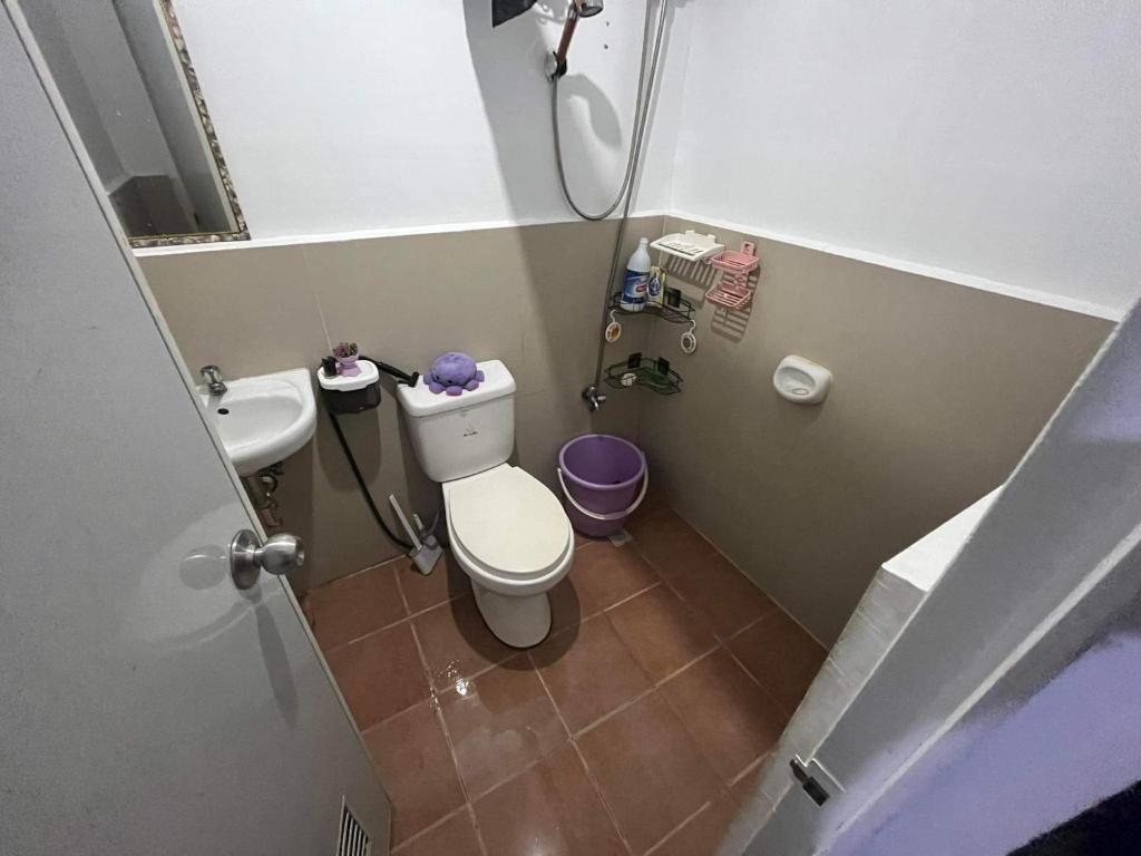 La petite salle de bains est pourvue de toilettes et d'un lavabo. dans l'établissement Fionas Apartment, à Manille