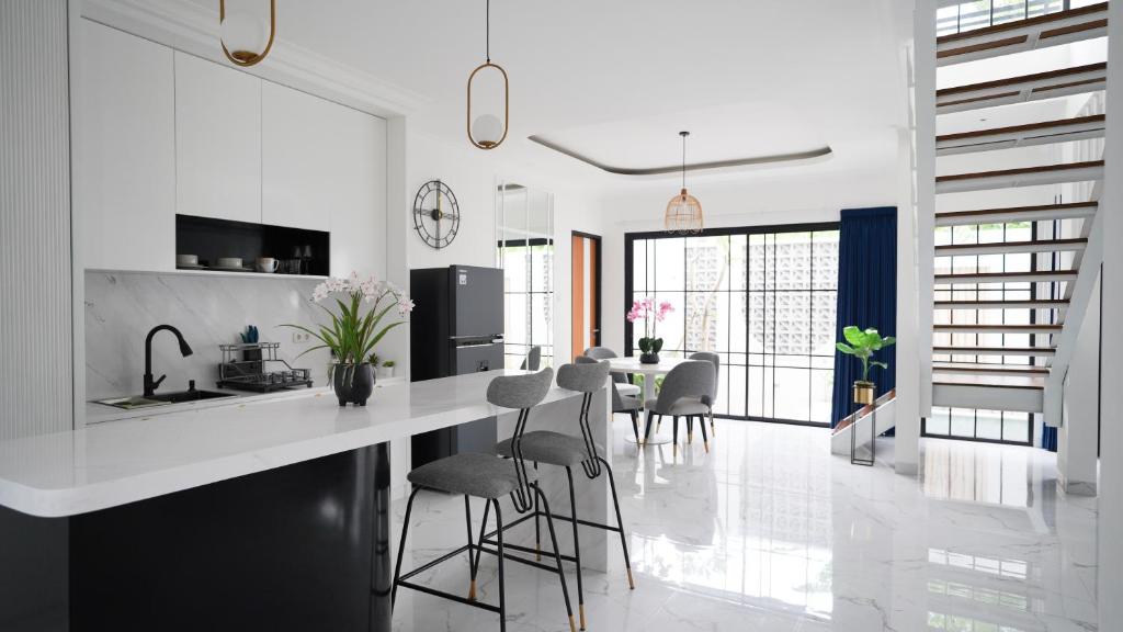 una cocina blanca con encimera y taburetes en Inori Villas, en Canggu