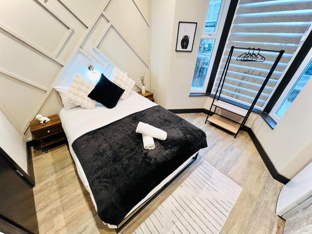 a bedroom with a bed with a black comforter at Charm Central Studio in London