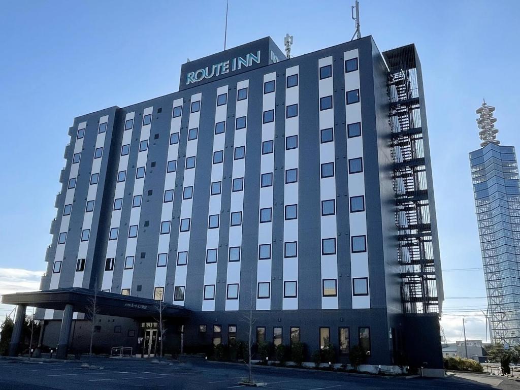 un edificio de hotel con un cartel encima en Hotel Route-Inn Akita Tsuchizaki, en Akita