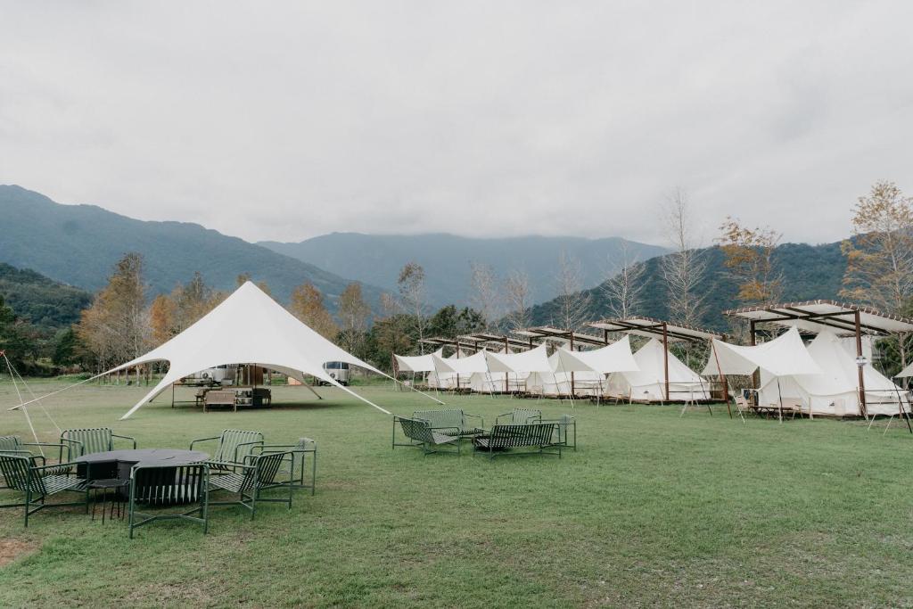 a group of tents in a field with tables and chairs at The Silence Manor in Ruisui