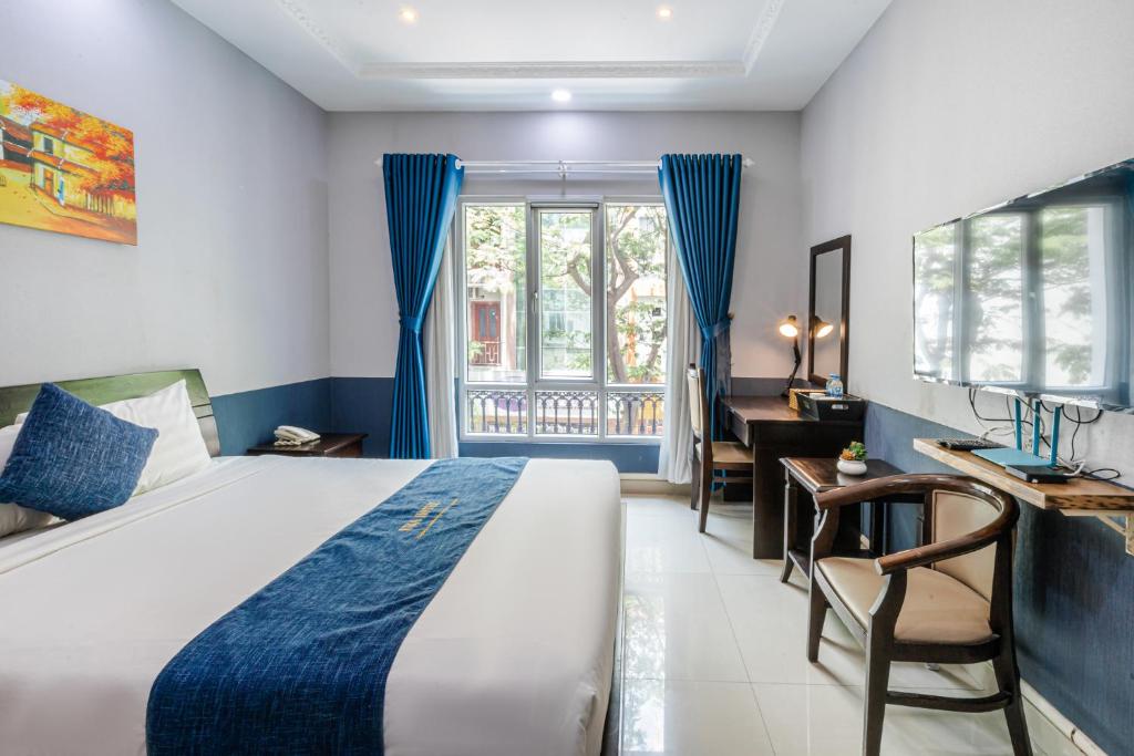 Schlafzimmer mit einem Bett, einem Schreibtisch und einem Fenster in der Unterkunft La Serena Boutique Hotel in Ho-Chi-Minh-Stadt