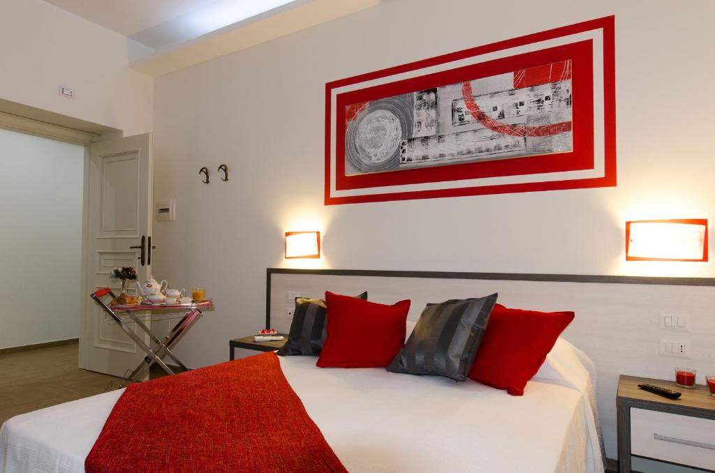 um quarto com uma grande cama branca com almofadas vermelhas em Gemme Di Roma Accomodation em Roma