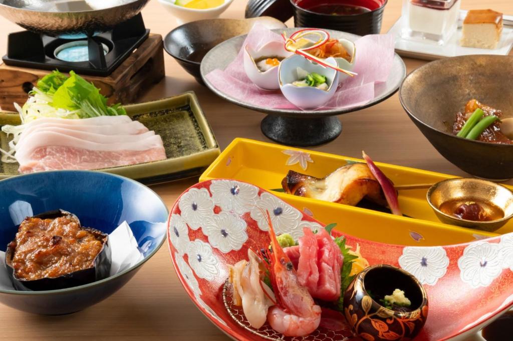 a table full of plates of food on a table at 奥松島LANEホテル in Tōna