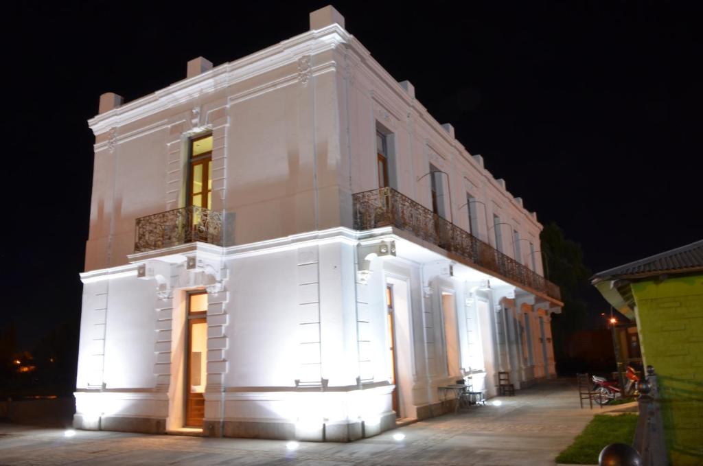 un edificio blanco con luces encendidas por la noche en Hotel El Recreo en General Roca