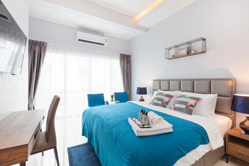 a bedroom with a blue bed with a tray on it at Reach Patong beach in one minute in Patong Beach