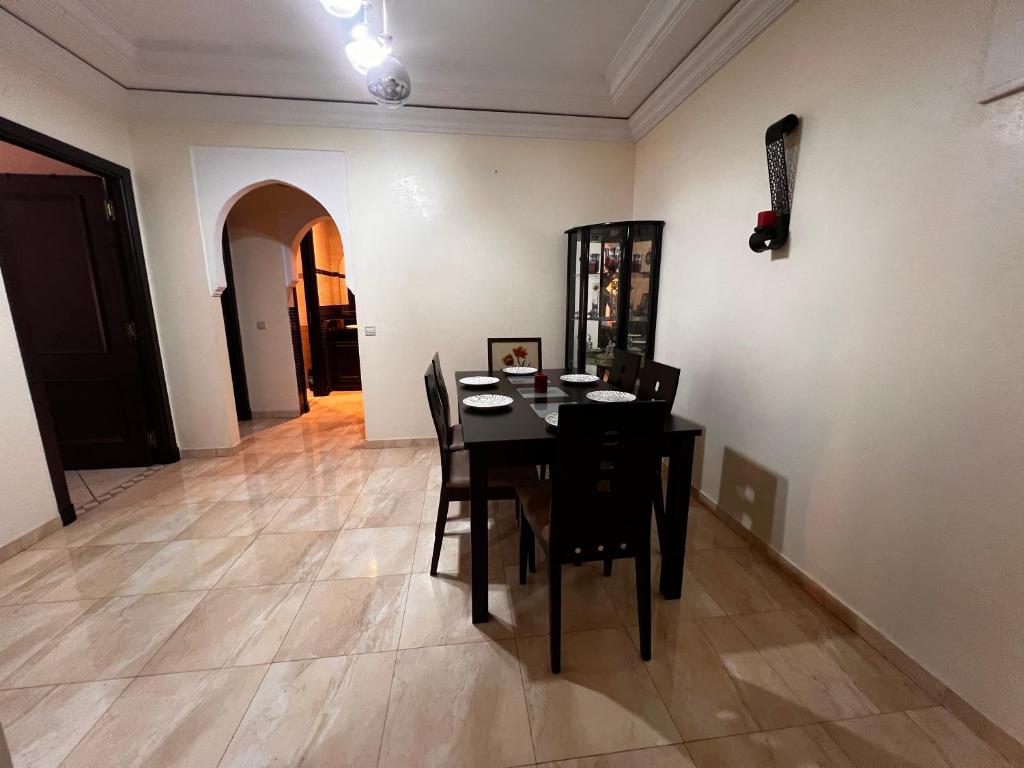 a dining room with a black table and chairs at Magnifique, Appartement, familial, spacieux 2chambres salon salle à manger in Marrakesh
