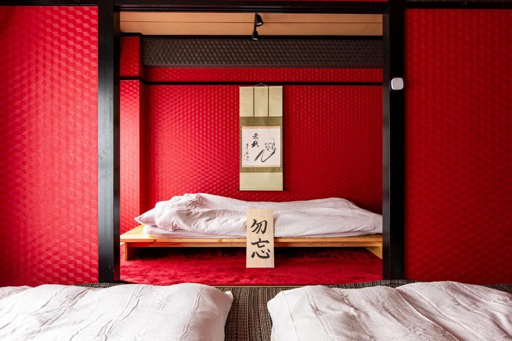 a bedroom with red walls and two beds and a sign at Geisha Expelience Stay in Tokyo