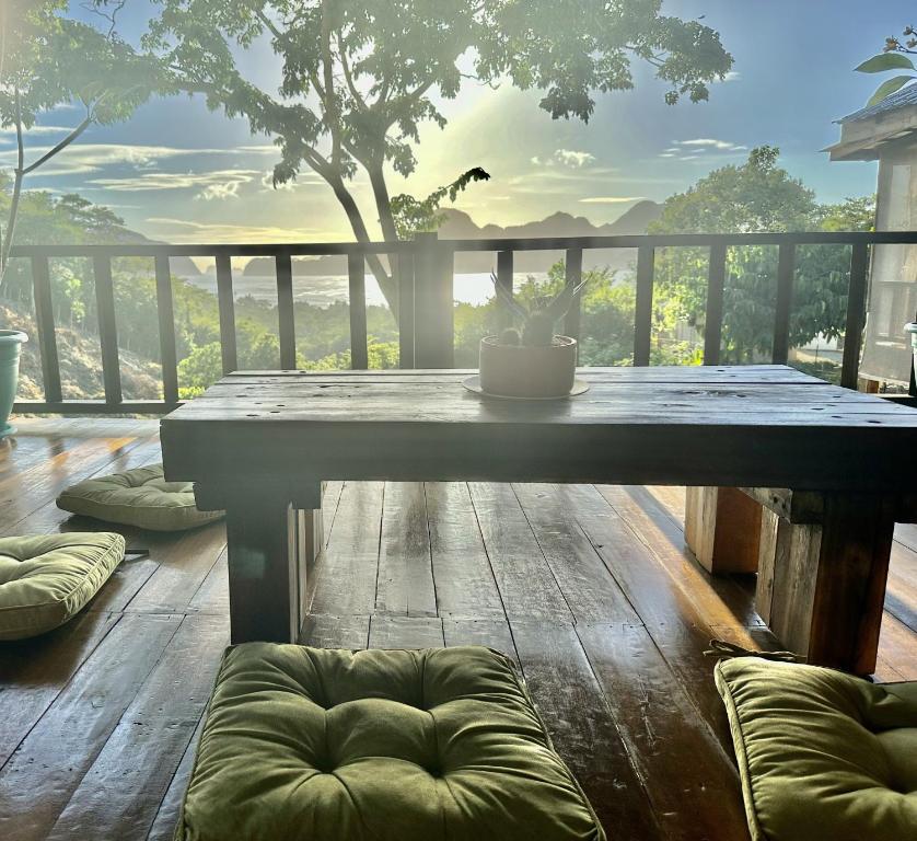 a table on a deck with a view of a tree at TukoKubo in El Nido