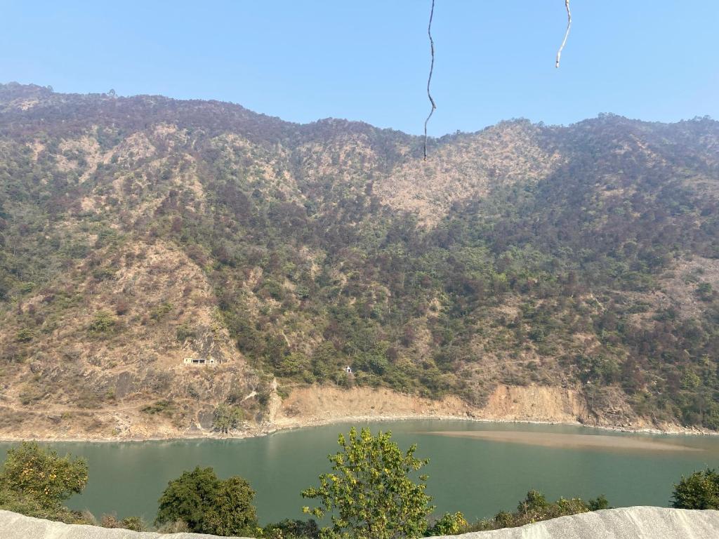 um lago em frente a uma montanha em Motel on Mountain & Mom ki Rasoi em Srīnagar