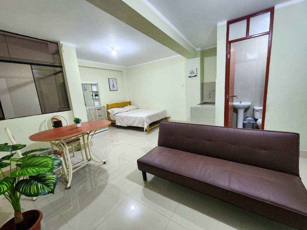 ein Wohnzimmer mit einem Sofa, einem Bett und einem Tisch in der Unterkunft Karibana in Huarmey
