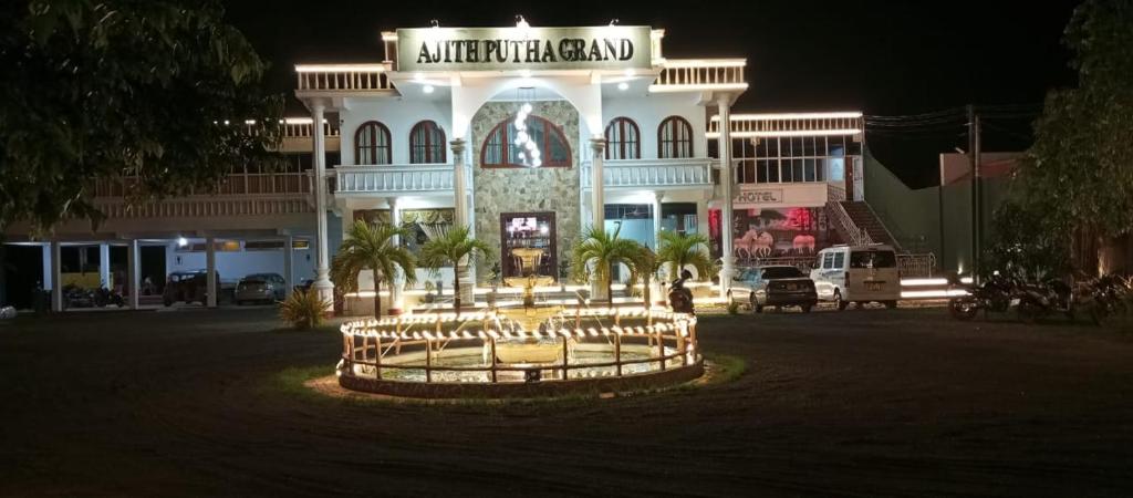 un gran edificio con un cartel delante de él por la noche en Ajith Putha Grand, en Madampe
