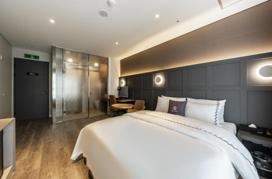 Postel nebo postele na pokoji v ubytování Gimpo JK Hotel