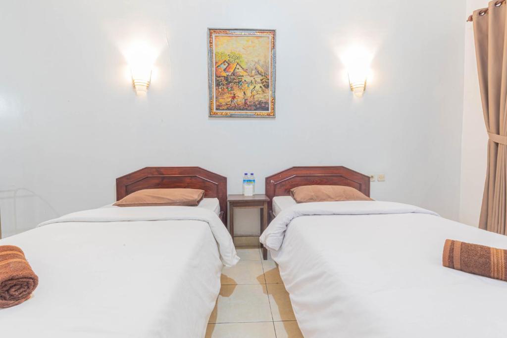 Postel nebo postele na pokoji v ubytování Transit Inn Senggigi