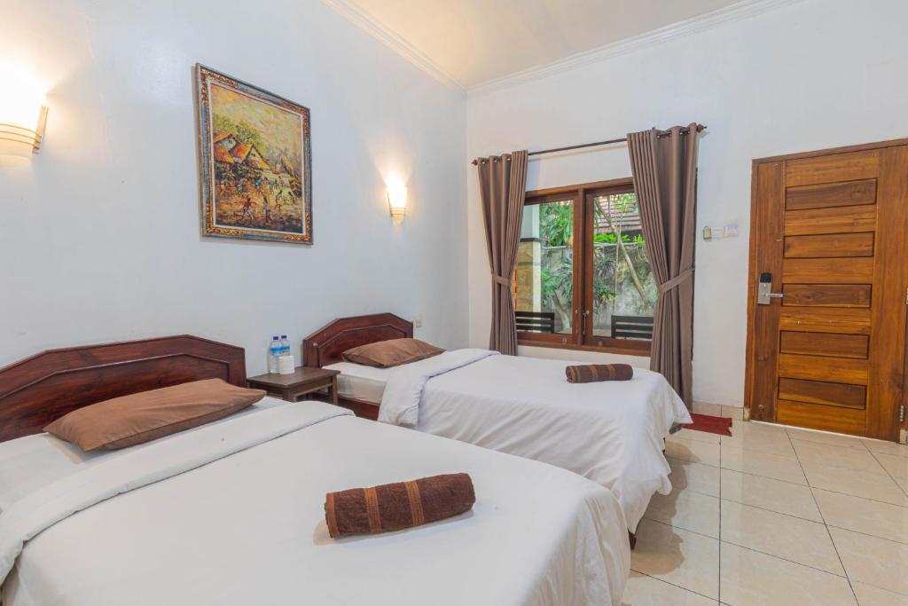 Postel nebo postele na pokoji v ubytování Transit Inn Senggigi