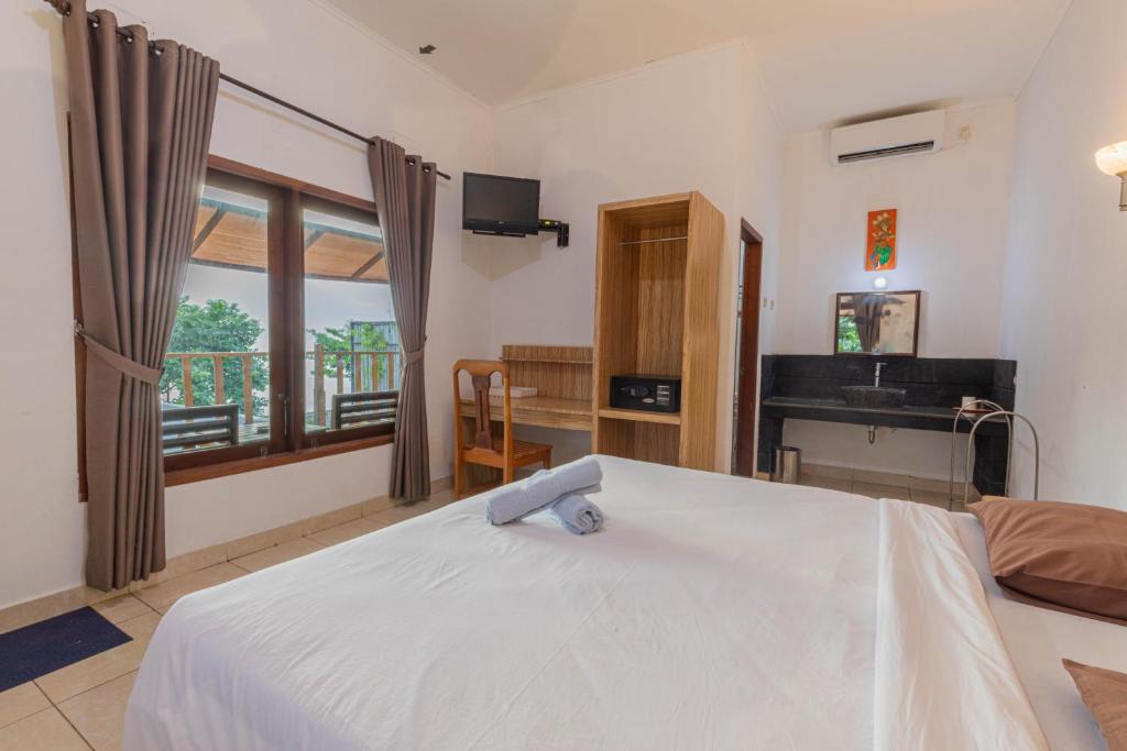 Postel nebo postele na pokoji v ubytování Transit Inn Senggigi