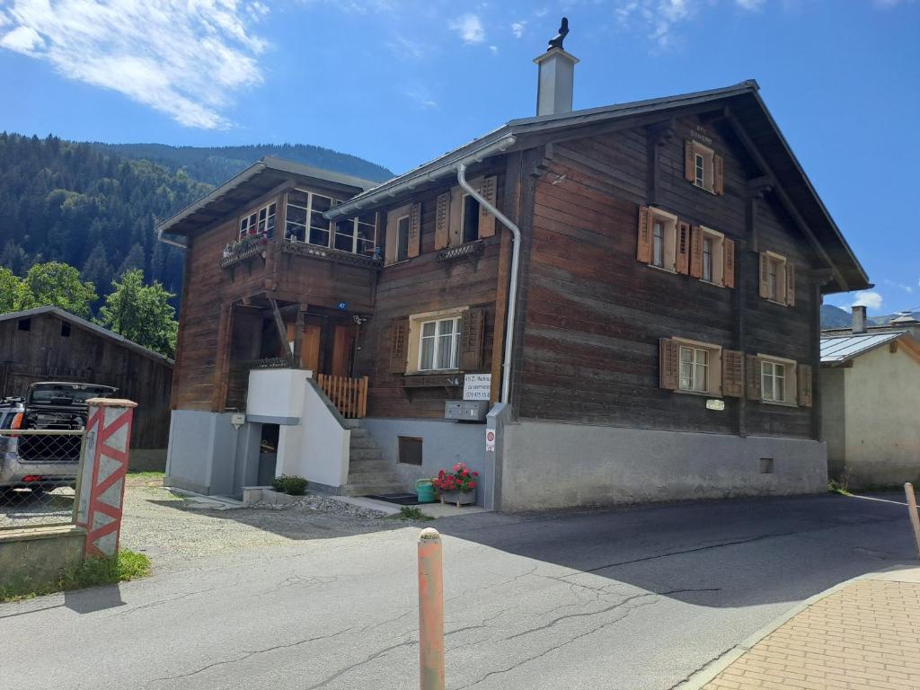 a large wooden house with a porch on a street at Haus Dani Danis in Danis