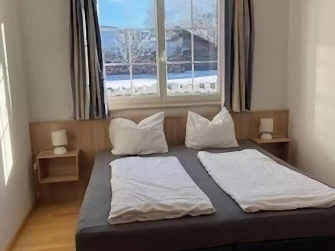 a bed with two pillows and a window in a room at Apartment in Sankt Margarethen near ski area in Sankt Margarethen im Lungau
