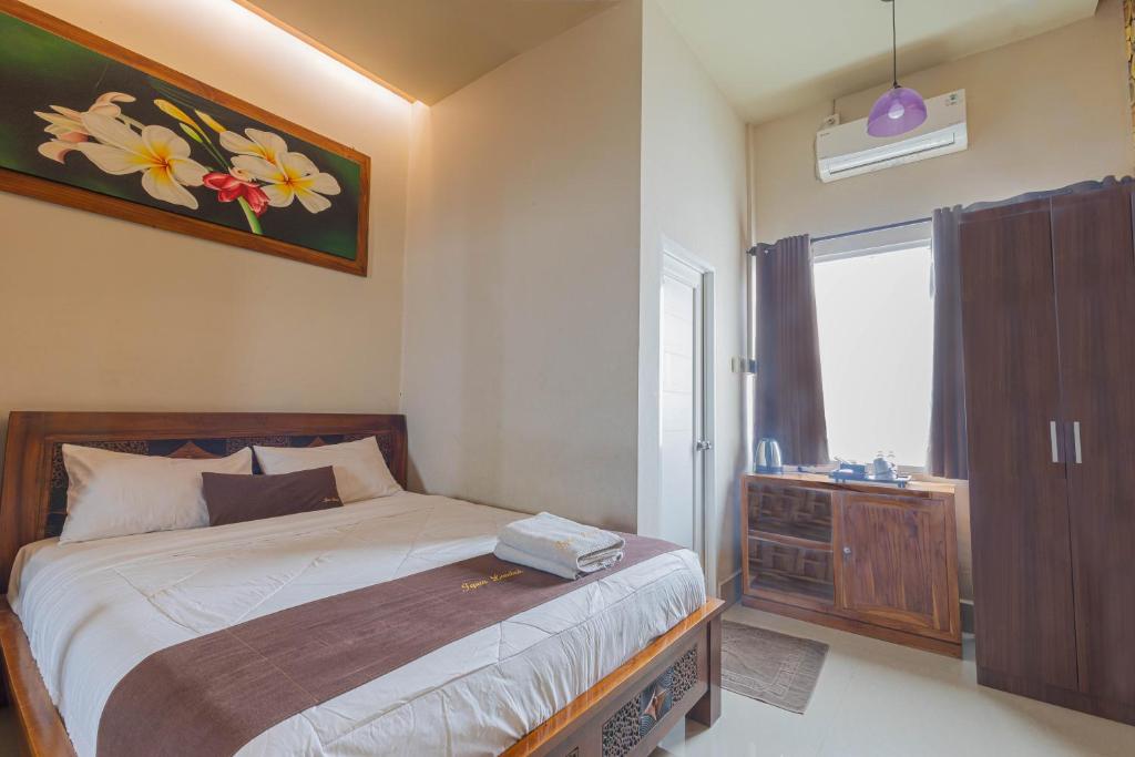Jepun Guest House في ماتارام: غرفة نوم بسرير ونافذة