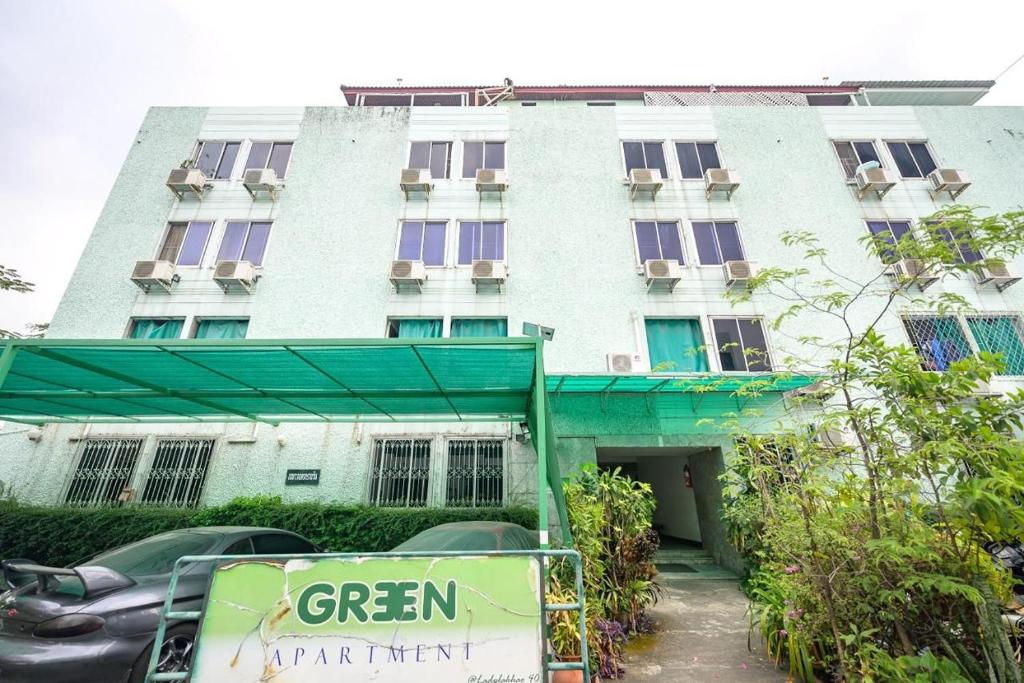 ein Gebäude mit einem grünen Schild davor in der Unterkunft Green Apartment Kaset in Bangkok