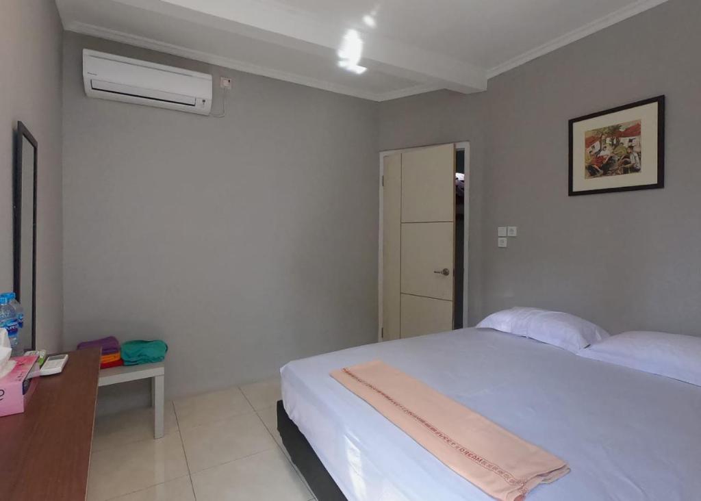 - une chambre avec un lit blanc, un bureau et une sidx dans l'établissement Griya Bausasran, à Sentool