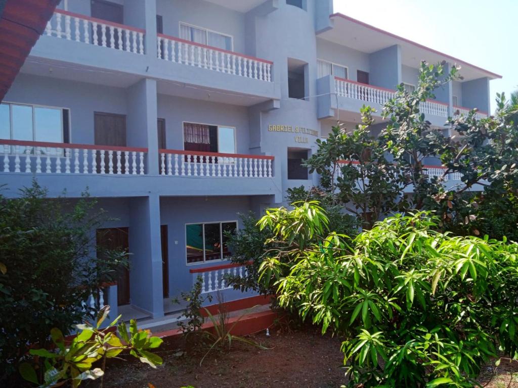 een gebouw met balkons en bomen ervoor bij Gabriel & Felicidade Villa in Mandrem