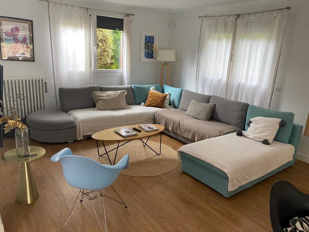 a living room with a couch and a chair at La villa Garonne avec piscine in Toulouse