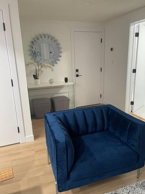 a blue couch in a living room with a mirror at Stylish 2 Bedroom suite in SW Edmonton close to Windermere and Edmonton International Airport in Edmonton