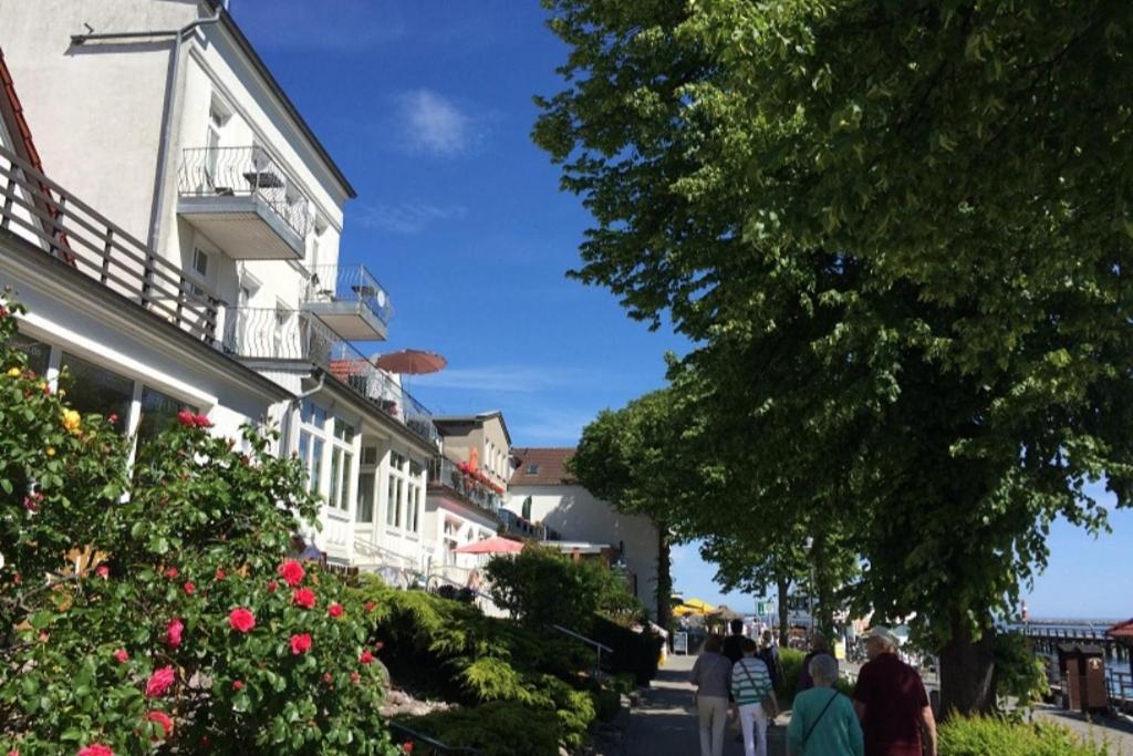 a group of people walking down a street next to a building at Haus Stromblick, Zimmer am Strom in Warnemünde