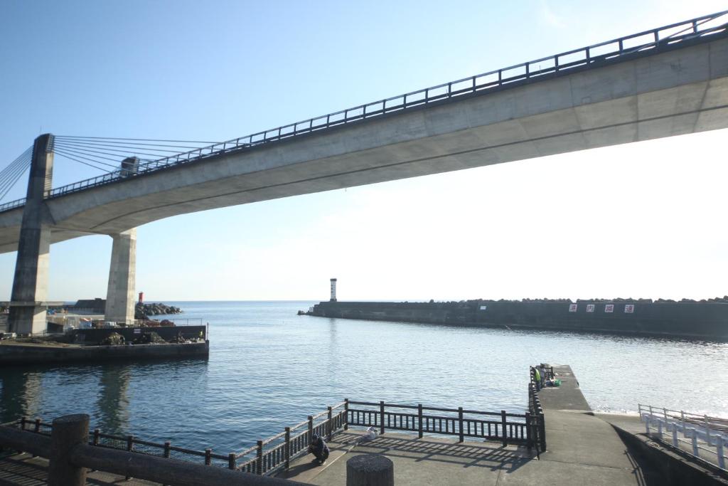 un puente sobre un cuerpo de agua con un barco en Seaside Harbor Odawara シーサイド ハーバー 小田原, en Odawara