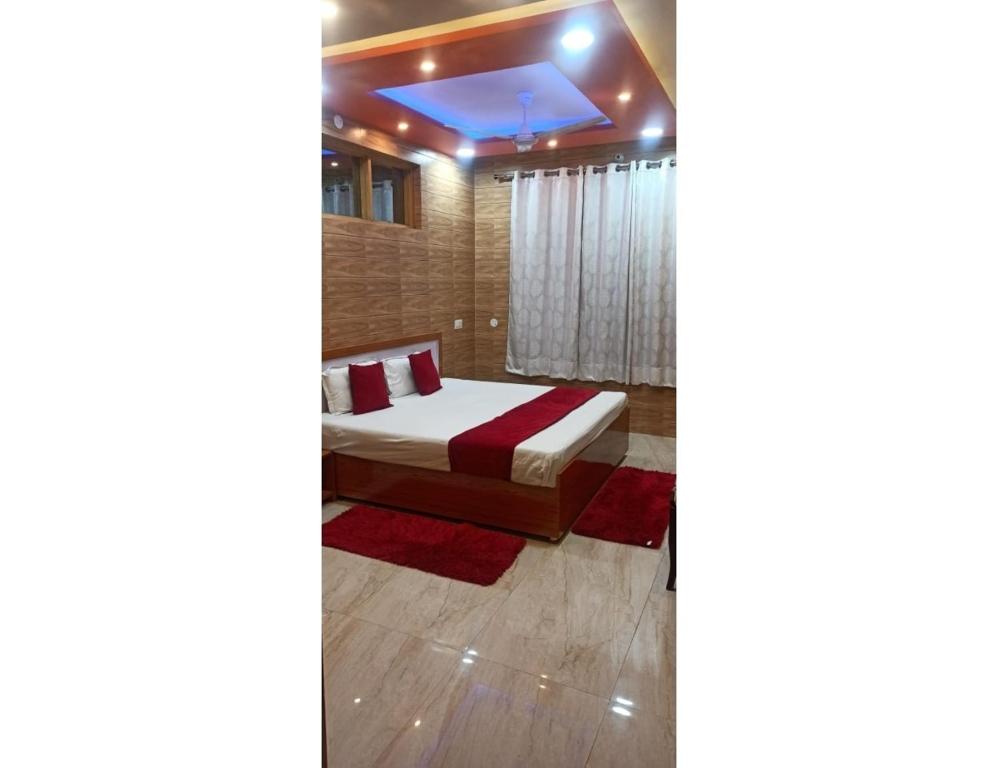 een slaapkamer met een bed en een raam erin bij Regency Hotel and Restaurant, Sarkaghat, HP 