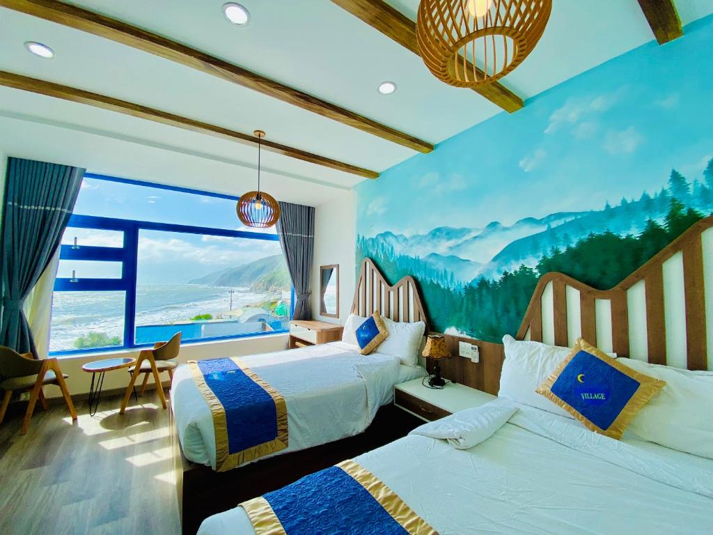 una camera d'albergo con due letti e una grande finestra di Chai Village Hotel a Quy Nhon