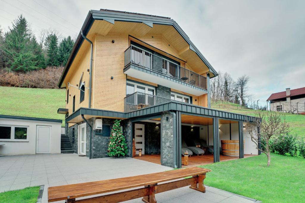 une maison avec une grande terrasse et un banc dans l'établissement Apartment Hanny, à Laško