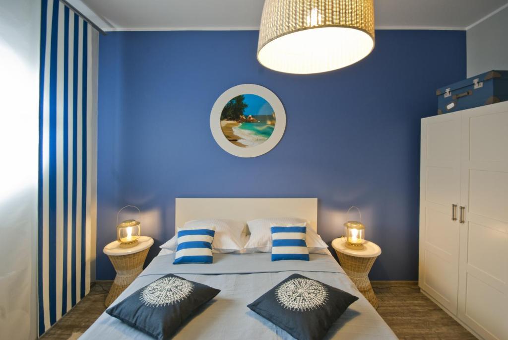 a blue bedroom with a bed with blue walls at Apartamenty Marina House in Bydgoszcz